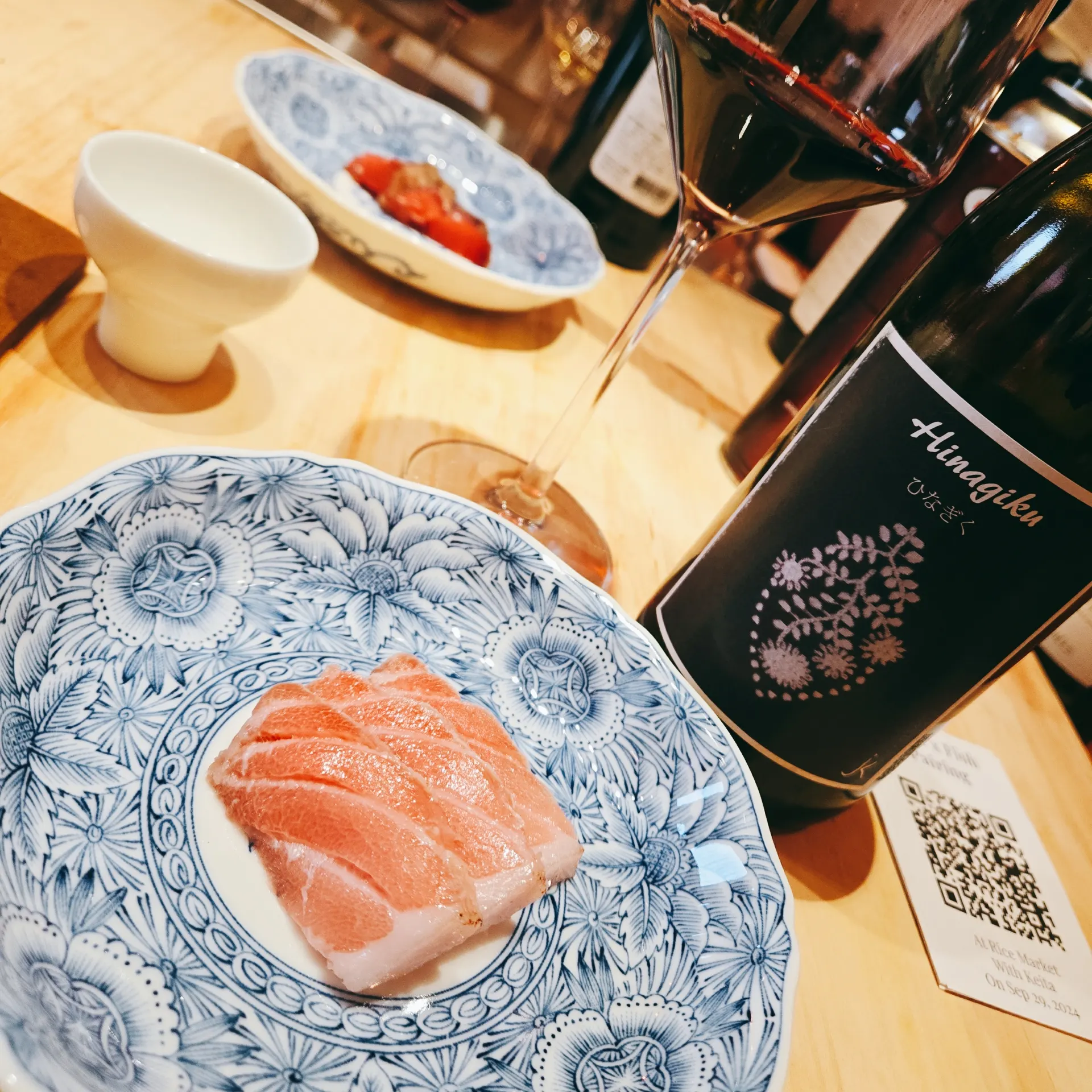 Red wine in a glass alongside Bluefin Tuna sashimi on a plate — Sashimi DC Washington DC